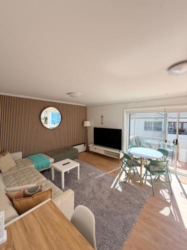 a living room with a couch and a table at Beachside Apartment Blackwoods Beach in Cronulla