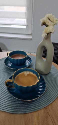 two bowls of coffee on a table with a vase at ILIRIA's Home in Făgăraş