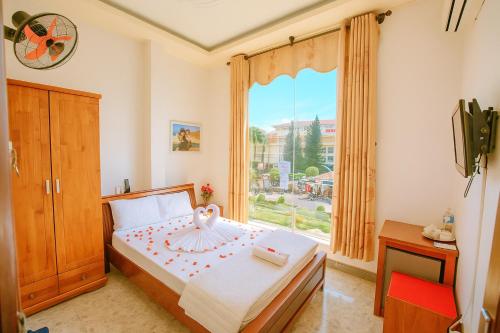 a bedroom with a bed with a large window at Phú Vang Hotel Pleiku in Pleiku
