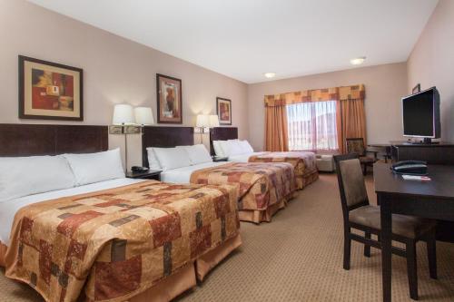 a hotel room with two beds and a desk at Ramada by Wyndham Brooks in Brooks