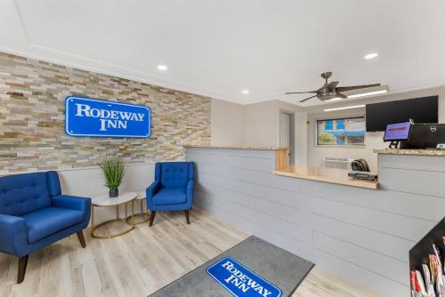 a lobby with two blue chairs and a sign that reads roadway firm at Rodeway Inn Lyons - La Grange in Lyons