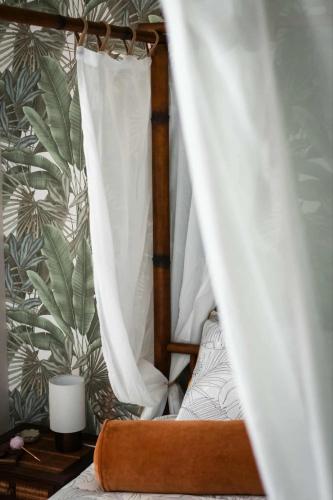 a bedroom with a bed with a canopy and a plant wall at Suite Eden Jungle - Ambiance tropicale cosy in Limoges