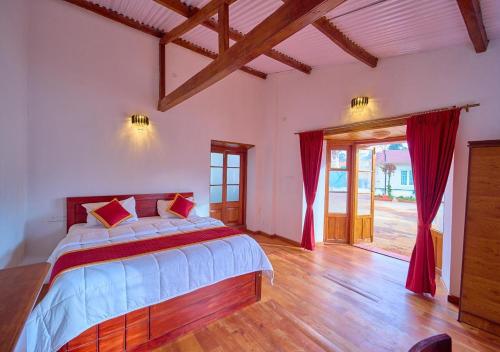 乌提Shivvs Heritage Resort Ooty的一间卧室配有一张带红色窗帘的大床