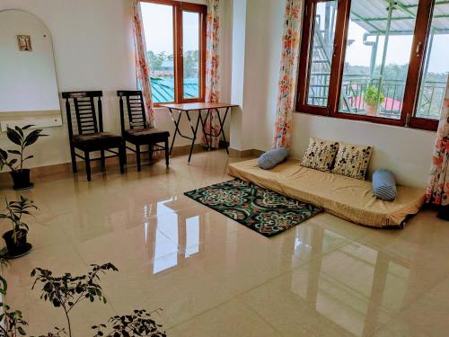 a living room with a couch and a table and windows at Akása Homes by Cosmic Kriya in Palāhu