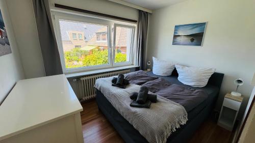 a small bedroom with a bed with a window at LUV & LEE Waterkant SPO in Sankt Peter-Ording
