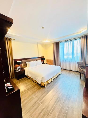 a hotel room with a bed and a chair at Muong Thanh Vinh Hotel in Vinh