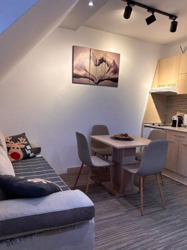 a living room with a table and a kitchen at Tri-M Konaci in Kopaonik