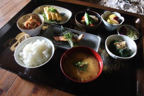 a tray with bowls of food and rice on a table at 信州の古民家宿 真秀ろばmahoroba in Nagano