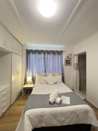 a bedroom with a large bed with two towels on it at Mario & Luiza's Place - Cozy Stay with Pool & Braai in Worcester