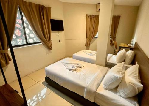 a hotel room with two beds and a window at Swing & Pillows - Chow Kit Road, Kuala Lumpur in Kuala Lumpur