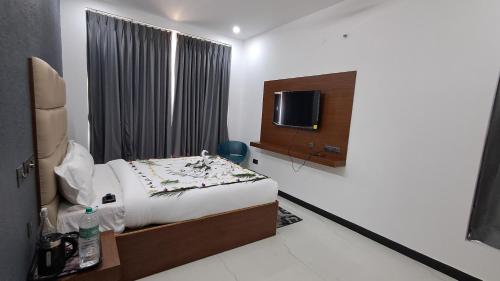 Una habitación de hotel con una cama y un televisor. en Forest Abode, en Yercaud
