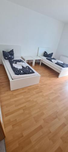 2 Betten in einem Zimmer mit Holzboden in der Unterkunft Möblierte 3-Zimmer-Wohnung im Herz von Schwandorf! in Schwandorf in Bayern