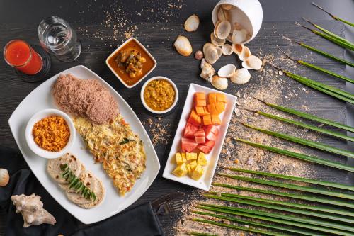 Una mesa cubierta con un plato de comida y verduras. en Amara Chairmans Bungalow, en Ahungalla