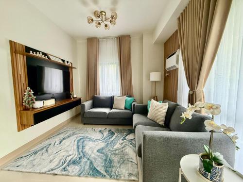 a living room with a couch and a tv at The Banyan Rest in Balibaguhan