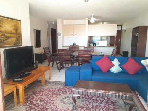 a living room with a blue couch and a television at Cicada 8 in Ramsgate