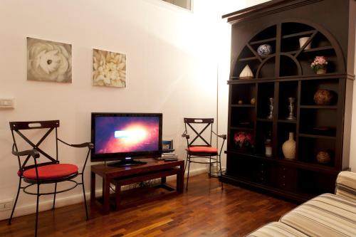 a living room with two chairs and a flat screen tv at Exclusive Aparthotel La Reunion in Ravenna