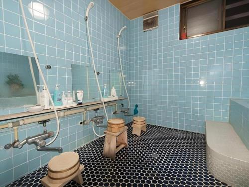 Baño de azulejos azules con 2 aseos y lavamanos en Country Inn Canadian House, en Akakura
