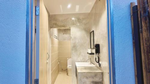 a bathroom with a sink and a toilet with a blue wall at TheNyaman Place in Hulu Langat