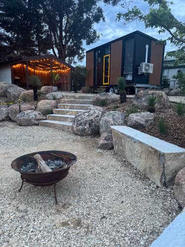 a fire pit in a yard next to a building at Gruyere Falls by Tiny Away in Gruyere