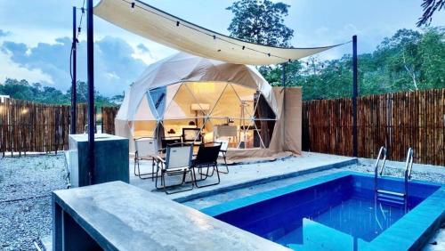 a yurt with a table and chairs next to a swimming pool at TheNyaman Place in Hulu Langat
