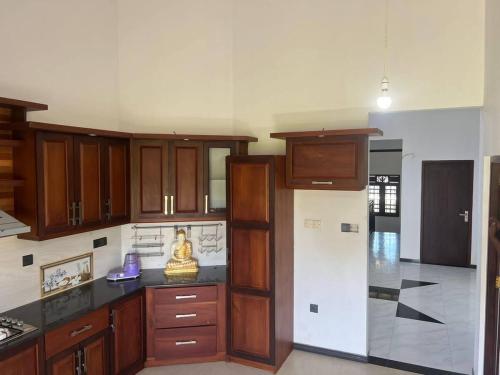 une cuisine avec des armoires en bois et un comptoir dans l'établissement Charming Retreat, à Matara