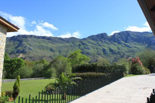 a house with a fence and mountains in the background at La QuintaEsencia in La Pereda de Llanes