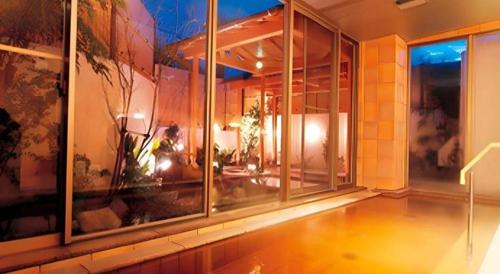 een groot gebouw met glazen ramen en een kamer met een tafel bij Sunshine Shirako New in Shirako