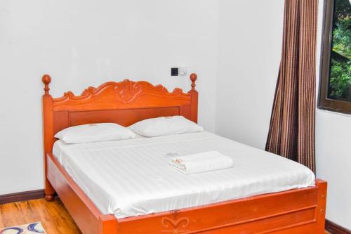 a bed with white sheets and white towels on it at Monalisa Studio Apartments in Gatunga