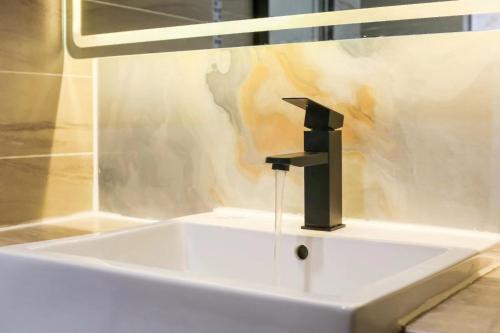 広州市にあるChenlong Cafe Hotelのバスルーム(洗面台、黒い蛇口付)