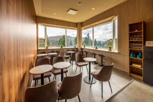 a restaurant with tables and chairs and windows at 箱根芦ノ湖 HOTEL RaKuun in Hakone