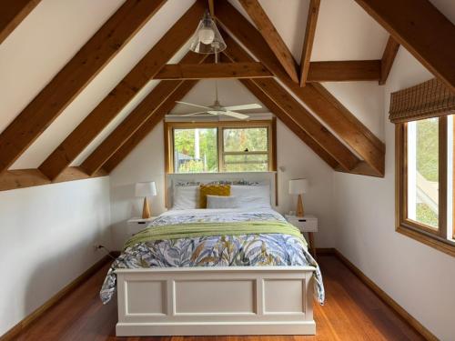 a bedroom with a white bed in a attic at Lower Mountains Retreat in Warrimoo