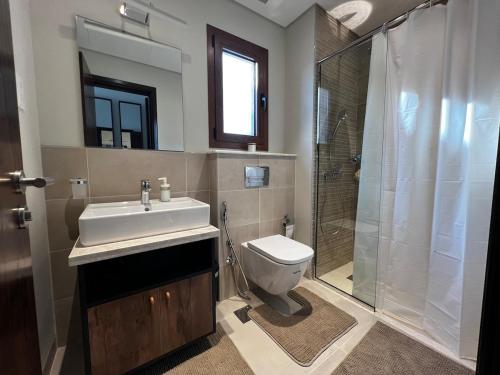 a bathroom with a toilet and a sink and a shower at Beiruty House -Elegant Family Seaside Villa in As Sīfah