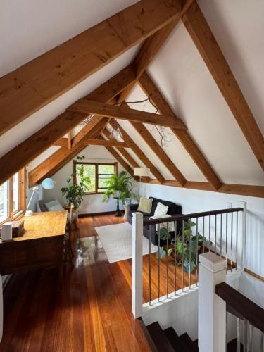 an attic room with wooden beams and a living room at Lower Mountains Retreat in Warrimoo