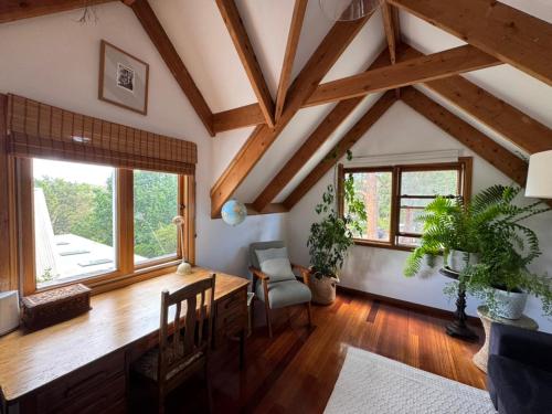 a living room with wooden ceilings and windows at Lower Mountains Retreat in Warrimoo
