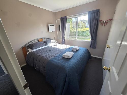 a bedroom with a bed with towels on it at The Retreat Taupo in Taupo