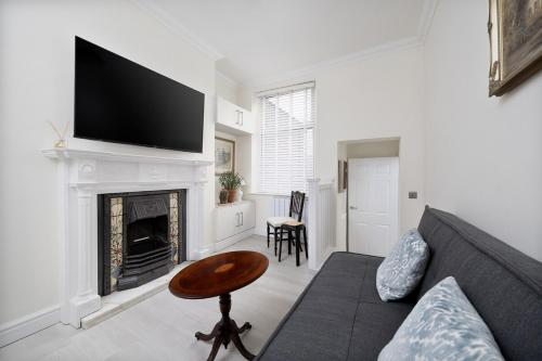 a living room with a couch and a fireplace at Beautiful 1-bed Apartment in Lincoln by Renzo, Lincoln Cathedral, Free Parking! in Lincoln
