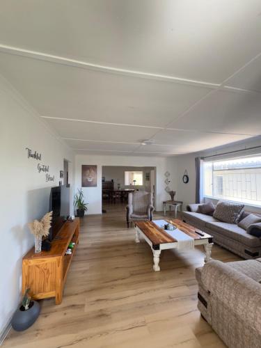 a living room with a couch and a table at Mario & Luiza's Place - Cozy Stay with Pool & Braai in Worcester