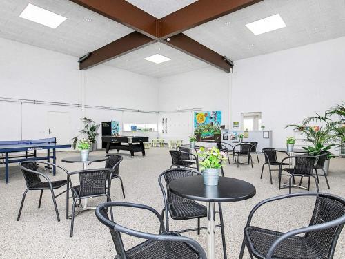 ein Zimmer mit Tischen, Stühlen und einem Klavier in der Unterkunft 6 person holiday home in Brovst in Brovst