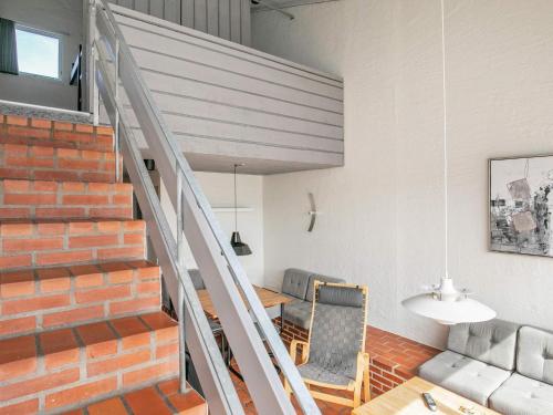 ein Zimmer mit einer Treppe, einem Tisch und einem Stuhl in der Unterkunft 6 person holiday home in Brovst in Brovst