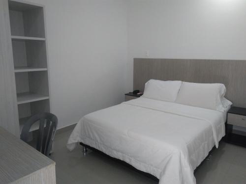 辛塞莱霍Hotel Boutique Santorini Class的卧室里有一张白色的床和一张书桌