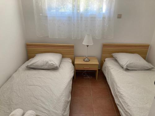 Domaine de la Brugaye Mimosa في Saint-Cézaire-sur-Siagne: سريرين توأم في غرفة بها نافذة