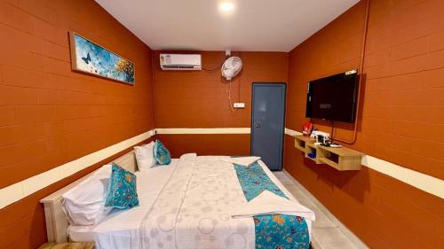 a bedroom with a bed and a flat screen tv at Metro Club Resort in Kāmānayakkanpālaiyam