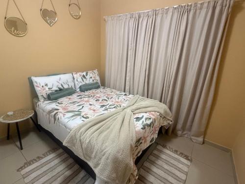 ein kleines Schlafzimmer mit einem Bett und einem Fenster in der Unterkunft Casa Palm and Tide holiday home in Swakopmund