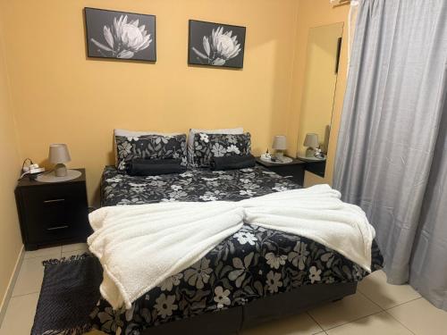 ein Schlafzimmer mit einem Bett mit einer schwarz-weißen Bettdecke in der Unterkunft Casa Palm and Tide holiday home in Swakopmund