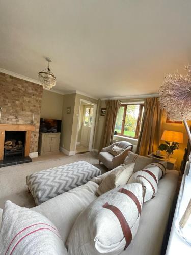 a living room with a couch and a fireplace at Oak Crest, 2 bedrooms, log fire, scenic views near Chapel Down in Rolvenden