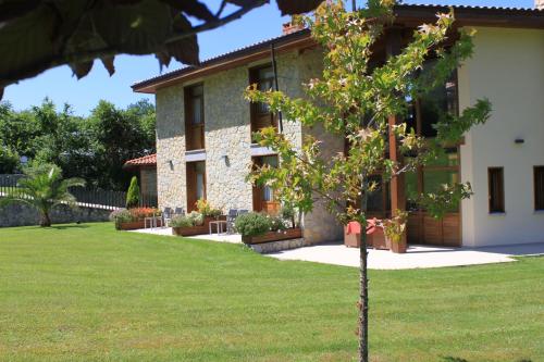 a small tree in front of a building at La QuintaEsencia in La Pereda de Llanes