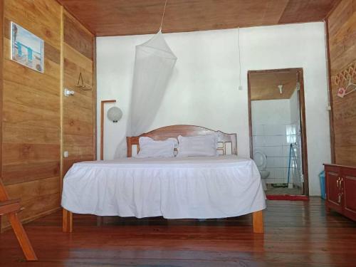 Savana Cottages في Letman: غرفة نوم بسرير وملاءات بيضاء ومرآة