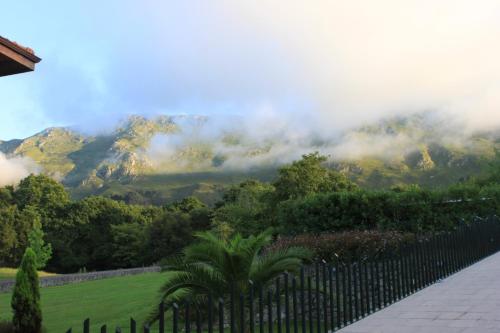 a fence in a garden with mountains in the background at La QuintaEsencia in La Pereda de Llanes