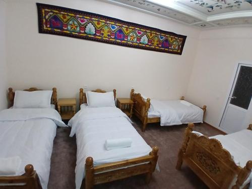 a room with three beds and a stained glass window at Shahina in Samarkand