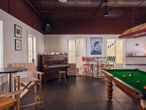 a living room with a pool table and a piano at Halse Lodge Noosa Heads in Noosa Heads